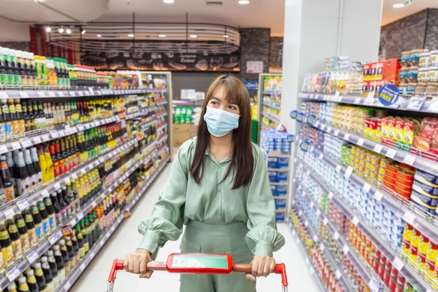 Mulheres usam máscaras para fazer compras em supermercados, novos estilos de vida normais na era do vírus Corona ou epidemia de Covid-19