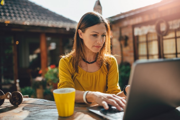 Mulheres usando laptop no pátio do quintal