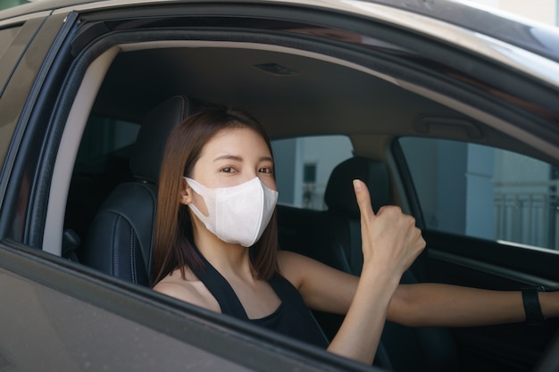 Mulheres usando máscara cirúrgica no carro, para proteção contra vírus corona ou Covid-19.