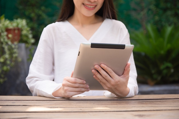 Mulheres usando tablet na mesa de madeira