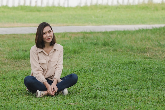 Mulheres vestindo camisas marrons sentado no gramado