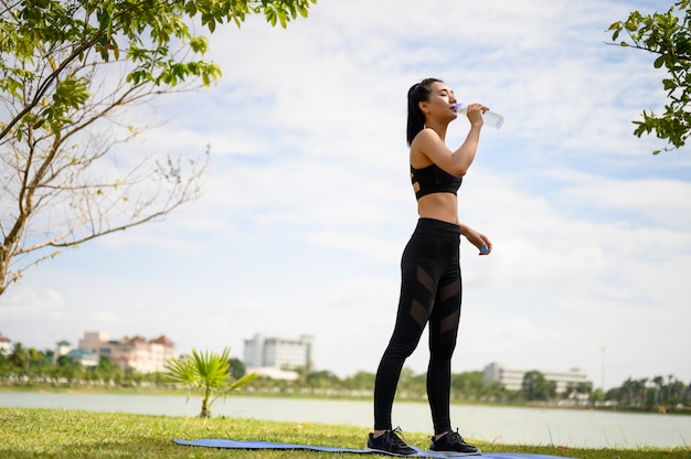 Mulheres vestindo roupas pretas para beber água enquanto caminhavam e corriam.