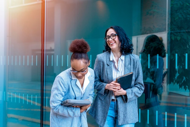 mulheres vestindo ternos de escritório com tablet digital conversando e sorrindo Conceito de parceiros de negócios alegres
