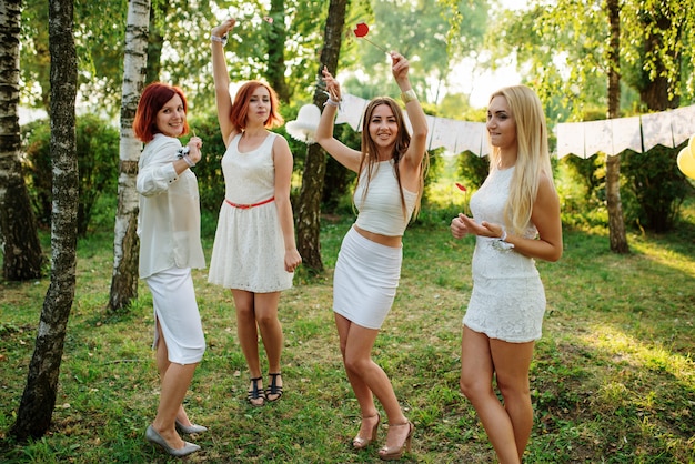 Mulheres vestindo vestidos brancos se divertindo na festa da galinha.