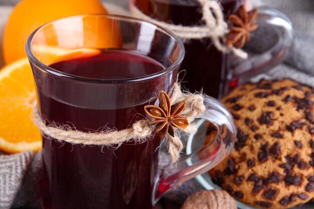 Mulled-Wein mit Orangen und Keksen auf dem Tisch aus der Nähe