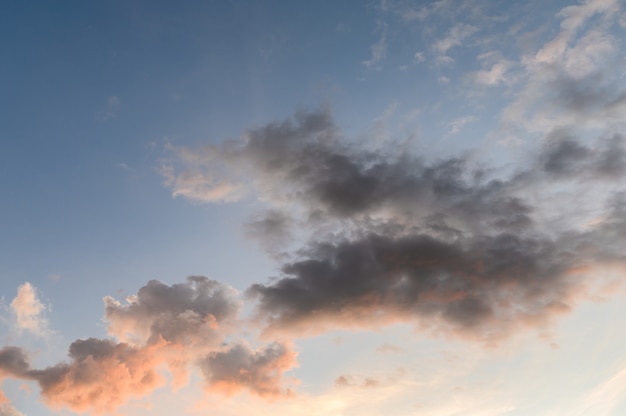 Mullidas nubes oscuras con sol en el cielo