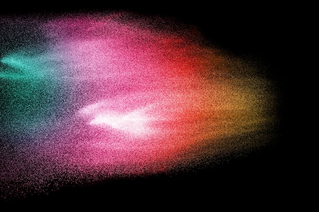 Multi explosão das partículas da cor no fundo preto.