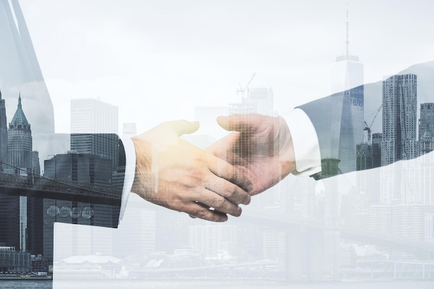 Multi exposição de aperto de mão de dois empresários no horizonte da cidade fundo cooperação e conceito de coworking