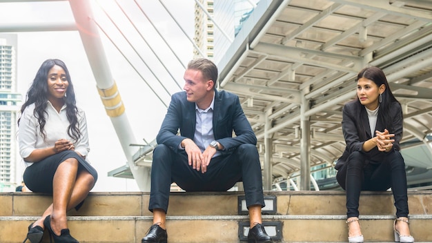 Multi Nationalität Business-Arbeiter Männer und Frauen sitzen auf der Treppe reden