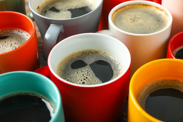 Multicoloridas xícaras de café na mesa de madeira como pano de fundo