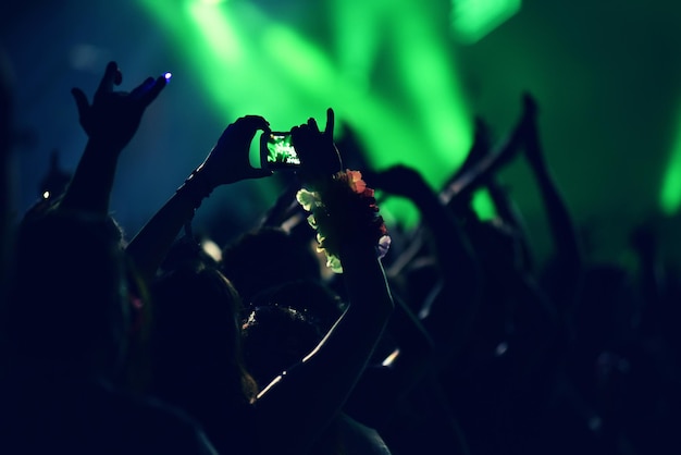 Multidão balançando durante um concerto com os braços levantados