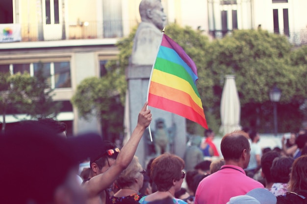 Multidão com bandeira do arco-íris durante o desfile do orgulho gay