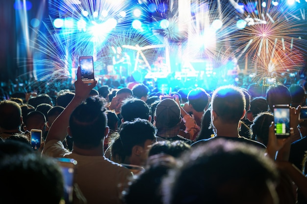 Multidão de concerto de música fanclub mão segurando o telefone inteligente móvel, tendo registro de vídeo ou transmissão ao vivo