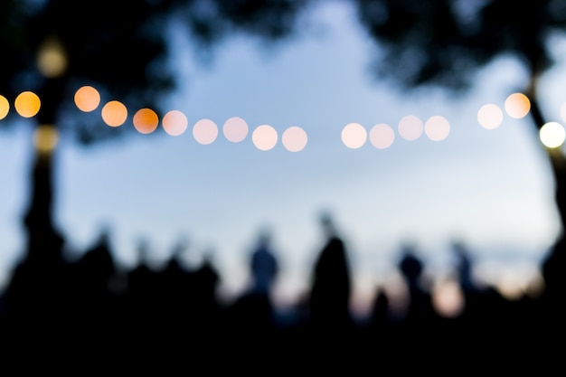 Multidão de pessoas ao ar livre esperando o pôr do sol