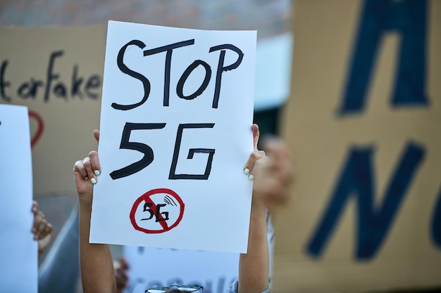 Multidão de pessoas irreconhecíveis protestando contra implantações de rede 5g