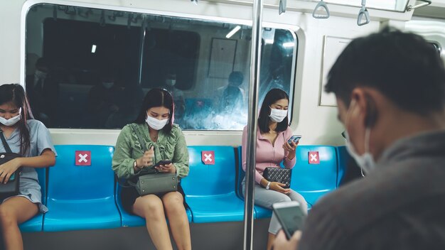 Multidão de pessoas usando máscara em uma viagem lotada de trem público de metrô