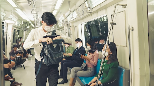 Multidão de pessoas usando máscara facial em uma viagem de trem público lotado