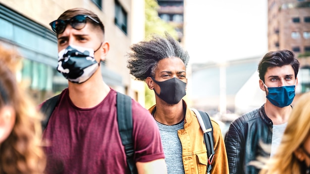 Multidão multirracial andando na rua da cidade com máscaras