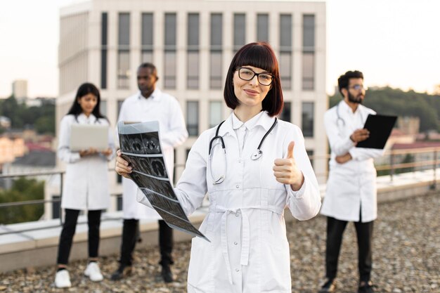 Foto multiethnic employees of clinic working on devices with results of examination