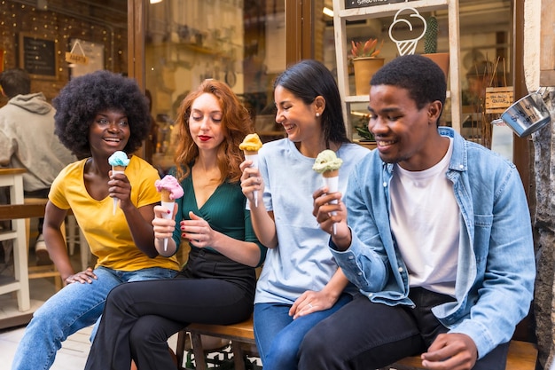 Multiethnische Freunde in einer Eisdiele, die im Sommer ein Eis essen und Spaß haben