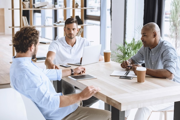 Multiethnische Geschäftsleute diskutieren Geschäftsidee beim Treffen im Büro