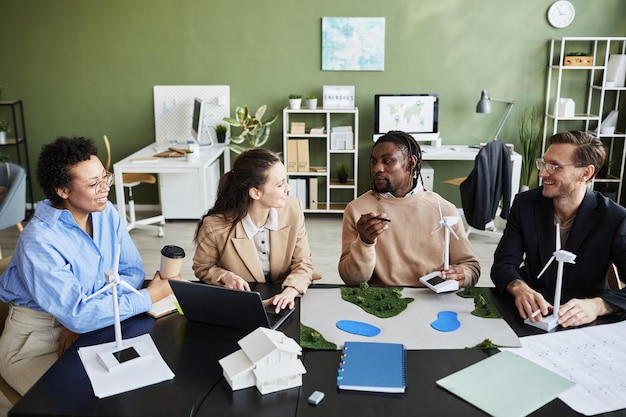 Multiethnische Gruppe von Ingenieuren, die im Team am Tisch im Büro an Energieprojekten arbeiten