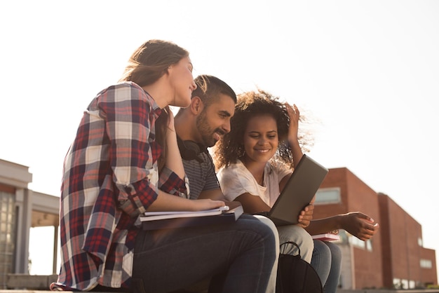 Foto multiethnische gruppe von studenten mit laptop auf dem campus - sanftes sonnenuntergangslicht