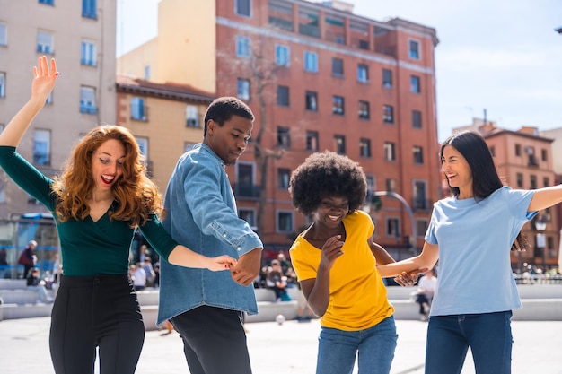 Multiethnische junge Freunde tanzen und lächeln in der Stadt und genießen eine Party mit Freunden