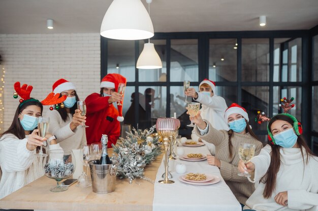 Multiethnische junge Leute, die Silvester feiern, stoßen an und gratulieren dem Trinken von Champagner