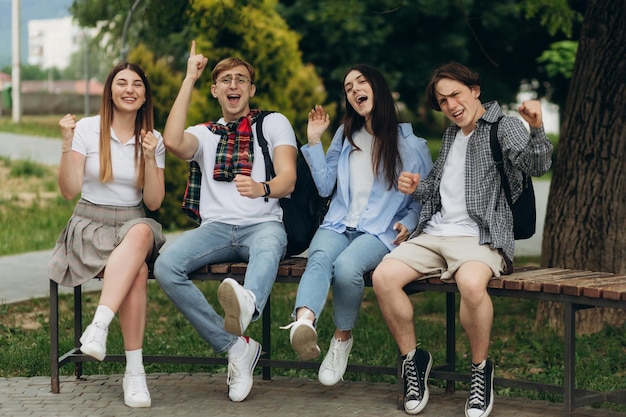 Multiethnische Studenten mit Taschen, die im Park gestikulieren