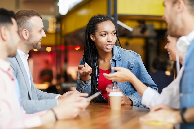 Multiethnische Studenten unterhalten sich im Café