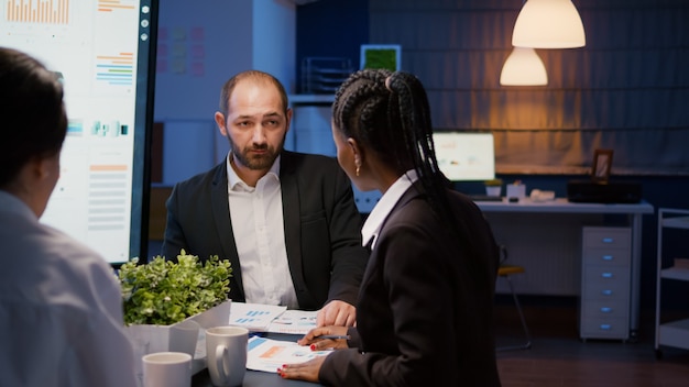 Foto multiethnische teamarbeit betritt den besprechungsraum des geschäftsbüros und diskutiert die unternehmensstrategie