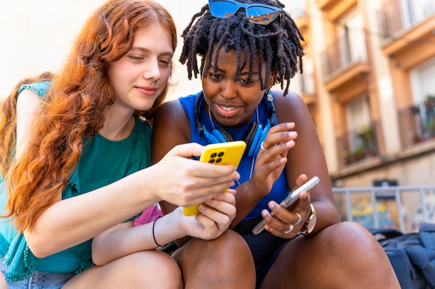 Multiethnisches Konzept Junge Frauen verschiedener Ethnien nutzen gerne gemeinsam Mobiltelefone