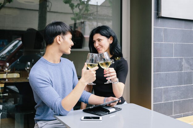 Multiethnisches Paar beim Toasten mit einem Glas Wein in einem Restaurant