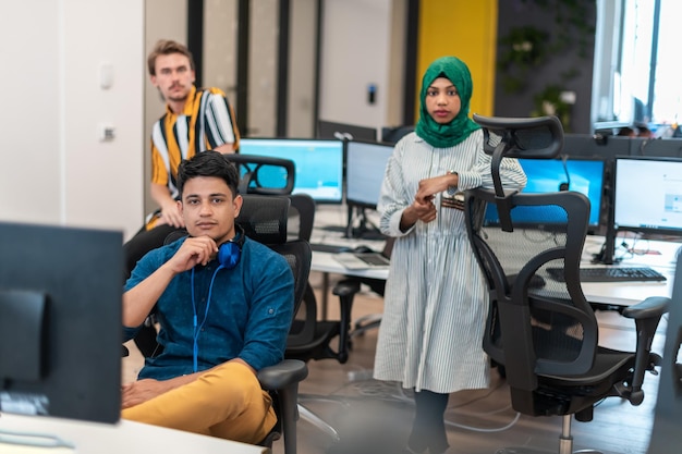 Multiethnisches Startup-Business-Team Arabische Frau, die einen Hijab trägt, trifft sich in einem modernen Großraumbüro zum Brainstorming, arbeitet an Laptop und Desktop-Computer. Selektiver Fokus. Hochwertiges Foto