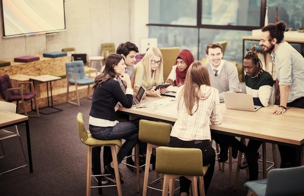 Multiethnisches Startup-Business-Team beim Treffen in einem modernen, hellen Büro-Interieur-Brainstorming, Arbeiten an Laptop und Tablet-Computer