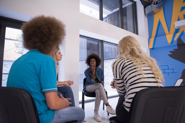 Multiethnisches Startup-Business-Team beim Treffen in einem modernen, hellen Büro-Interieur-Brainstorming, Arbeiten an Laptop und Tablet-Computer