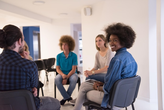 Multiethnisches Startup-Business-Team beim Treffen in einem modernen, hellen Büro-Interieur-Brainstorming, Arbeiten an Laptop und Tablet-Computer