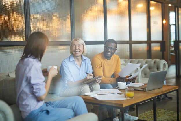 Multiethnisches Team, das im gemütlichen Café arbeitet