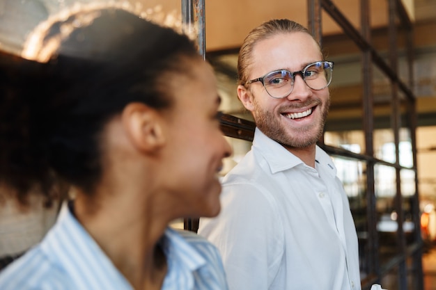 multinationale fröhliche Kollegen reden und lachen während der Arbeit im Büro