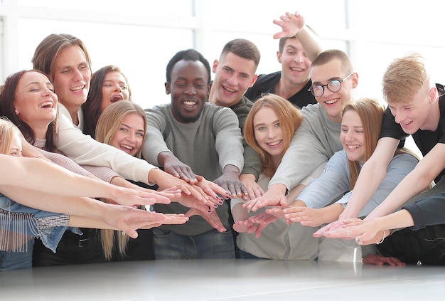 Foto multinationale gruppe junger menschen, die sich ihren handflächen anschließen