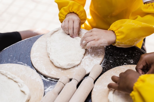 Multinationales Unternehmen von Kinderköchen kocht Teig Nahaufnahme Junge Köche Kinder kochen Khachapuri