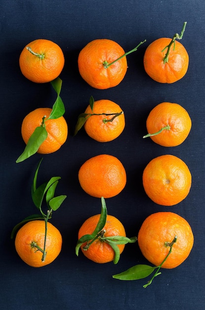 Múltiplas tangerinas maduras sobre visão aérea de pano azul escuro