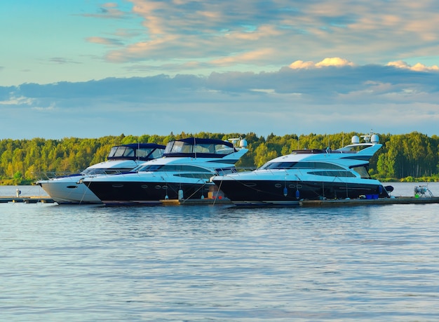 Múltiples barcos de yates en el fondo del río al atardecer