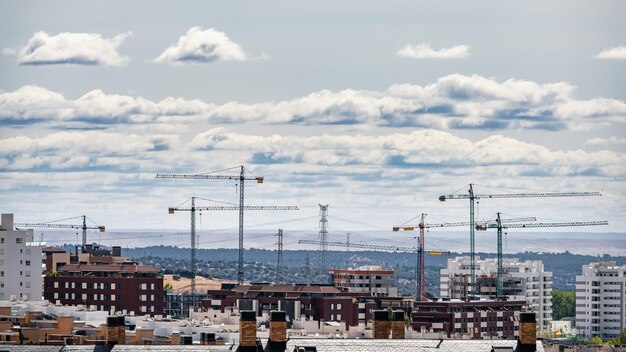 Múltiples grúas de construcción que destacan en el horizonte en nuevas zonas de expansión Madrid España