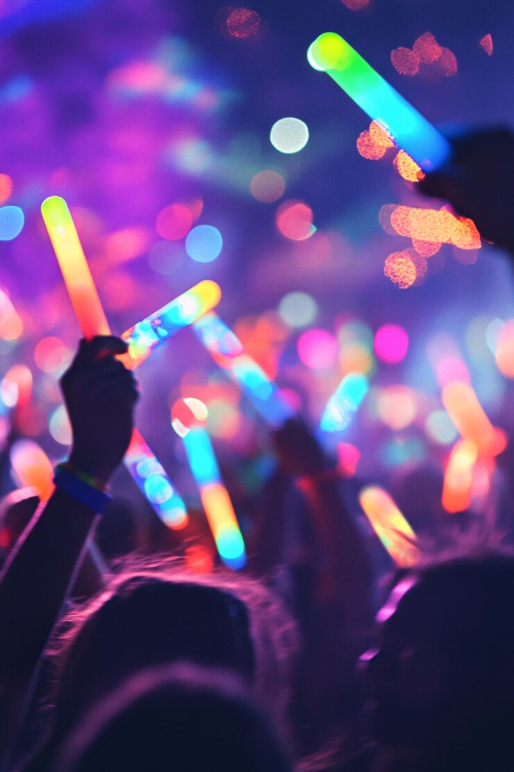 La multitud aplaudiendo con palos brillantes en un festival de música