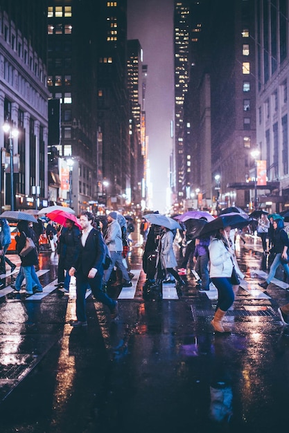 La multitud en el camino mojado por la noche