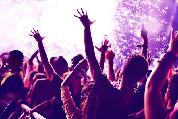 Multitud en un concierto de música contra fuegos artificiales durante la noche