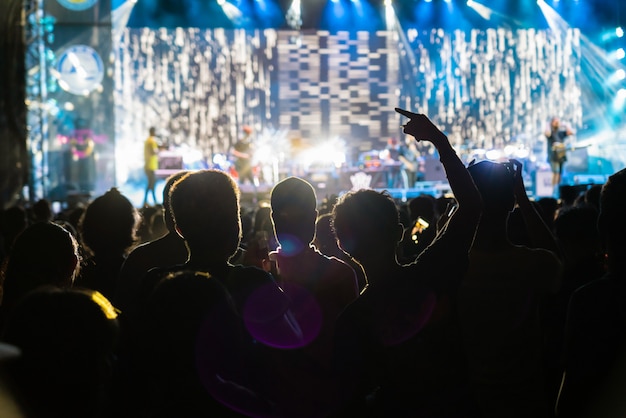 Multitud de conciertos en siluetas de fanclub de música con acción de espectáculo que sigue al songer en el frente del escenario con un concepto de luz, musical y concierto.