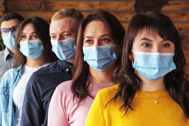 Foto multitud de jóvenes con máscaras en la cara durante la pandemia de coronavirus